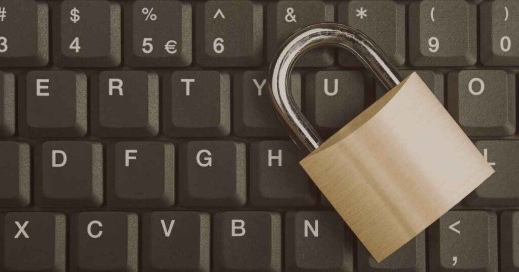 Brass padlock resting on a computer keyboard, representing protection of publishing accounts, ISBNs, and book rights
